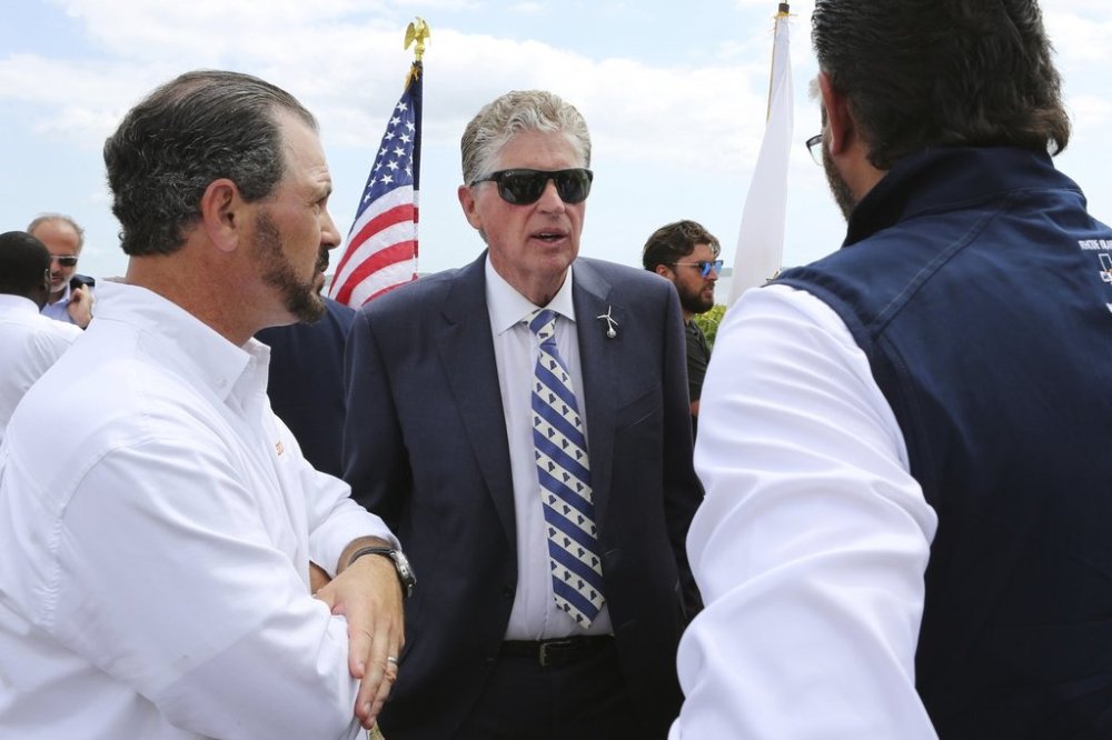 Rhode Island Gov. Dan McKee, center, speaks with Laborers' International Union of North America leaders Donato Bianco, left, and Michael Sabitoni, right, after a news conference in North Kingstown, R.I., on Monday, Aug. 25, 2025. Democratic politicians and union leaders called on the Trump administration to allow work to continue on the Revolution Wind offshore wind farm. (AP Photo/Jennifer McDermott)