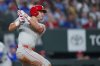 Philadelphia Phillies' Max Kepler follows through on a two-run double against the Texas Rangers during the seventh inning of a baseball game Saturday, Aug. 9, 2025, in Arlington, Texas. (AP Photo/Julio Cortez)