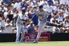 Los Angeles Dodgers' Freddie Freeman, right, is congratulated by third base coach Dino Ebel, left, as he rounds third after hitting a solo home run against the San Diego Padres in the sixth inning of a baseball game Sunday, Aug. 24, 2025, in San Diego. (AP Photo/Derrick Tuskan)