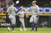 Milwaukee Brewers' Caleb Durbin, left, and Milwaukee Brewers' Andrew Vaughn, right, celebrate their win at the conclusion of the ninth inning of a baseball game against the Cincinnati Reds, Friday, Aug. 15, 2025, in Cincinnati. (AP Photo/Kareem Elgazzar)