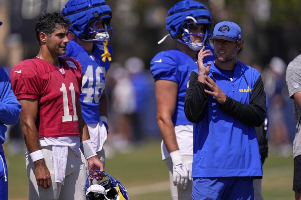 Los Angeles Rams quarterback Jimmy Garoppolo, left, talks with quarterback Matthew Stafford during a training camp scrimmage against the Dallas Cowboys, Tuesday, Aug. 5, 2025, in Oxnard, Calif. (AP Photo/Mark J. Terrill)