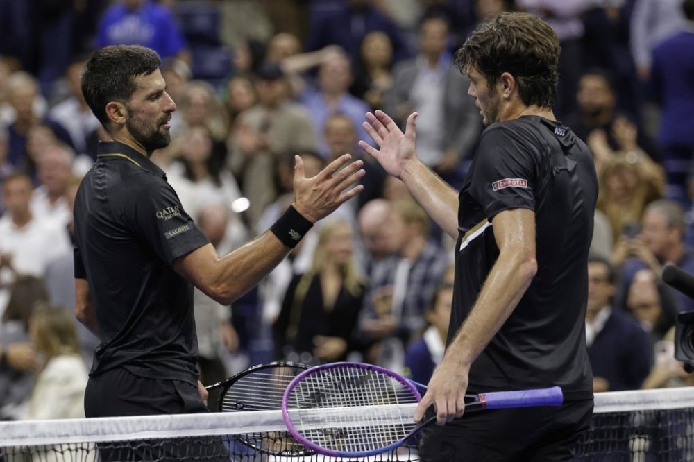 Novak Djokovic, of Serbia, shakes hands with Taylor Fritz, of the United States, after winning the match during the quarterfinal round of the U.S. Open tennis championships, Tuesday, Sept. 2, 2025, in New York. (AP Photo/Adam Hunger)