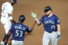 Seattle Mariners' Cal Raleigh (29) celebrates his single off Tampa Bay Rays pitcher Shane Baz with first base coach Eric Young Jr. (53) during the sixth inning of a baseball game Monday, Sept. 1, 2025, in Tampa, Fla. (AP Photo/Chris O'Meara)