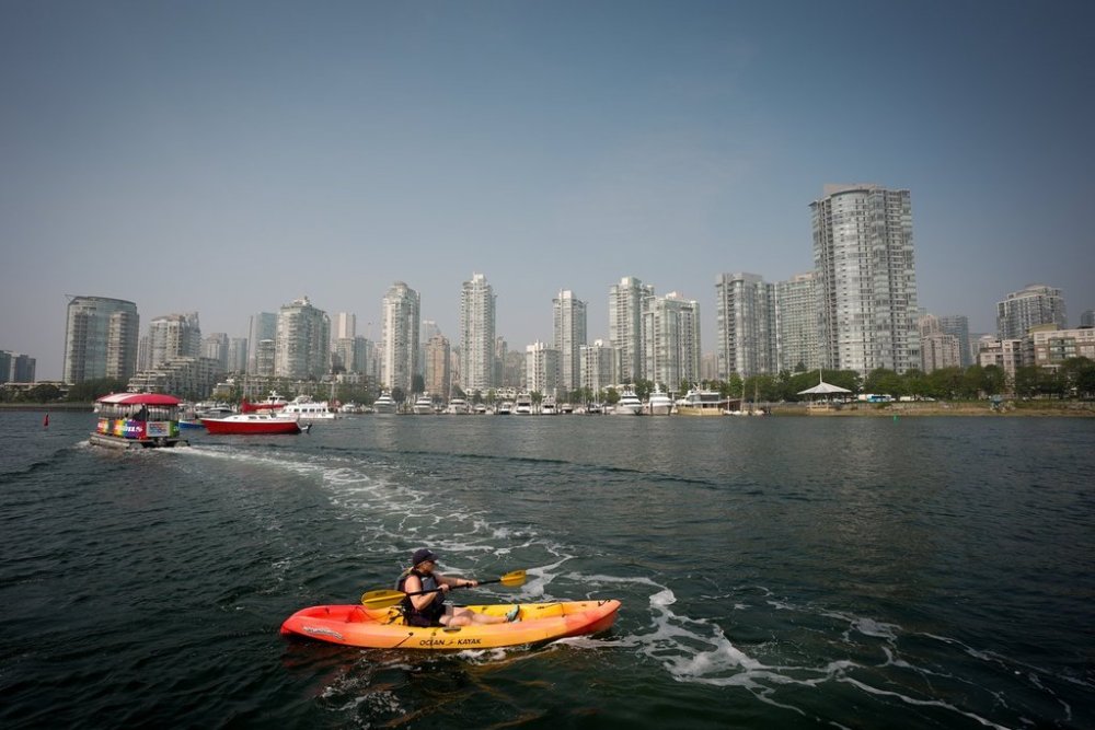 A woman paddles a kayak on False Creek as smoke from wildfires burning in B.C. and the U.S. hangs in the air, in Vancouver, B.C., Wednesday, Sept. 3, 2025. Environment Canada has issued an air quality warning in Metro Vancouver and the Fraser Valley due to the smoke that is expected to last for a few days or until there is a change in weather. THE CANADIAN PRESS/Darryl Dyck