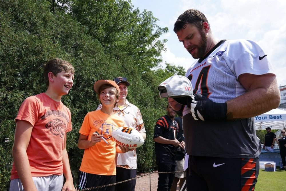 FILE - Cincinnati Bengals center Ted Karras (64) signs autographs during practice at the team's NFL football training camp, July 24, 2025, in Cincinnati. (AP Photo/Jeff Dean, File)