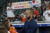 Fans hold a sign as Houston Astros third baseman Carlos Correa signs autographs during batting practice before a baseball game against the Boston Red Sox Monday, Aug. 11, 2025, in Houston. (AP Photo/David J. Phillip)