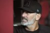 Arizona Diamondbacks manager Torey Lovullo checks the lineup posted on the team dugout wall prior to a baseball game against the Cleveland Guardians Monday, Aug. 18, 2025, in Phoenix. (AP Photo/Ross D. Franklin)