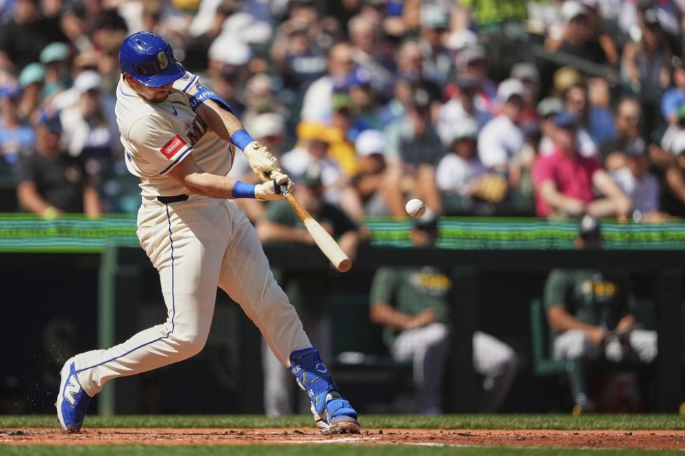 Seattle Mariners' Cal Raleigh hits a two-run home run to break the record for single-season home runs by a catcher at 49 against the Athletics during the second inning of a baseball game, Sunday, Aug. 24, 2025, in Seattle. (AP Photo/Lindsey Wasson)