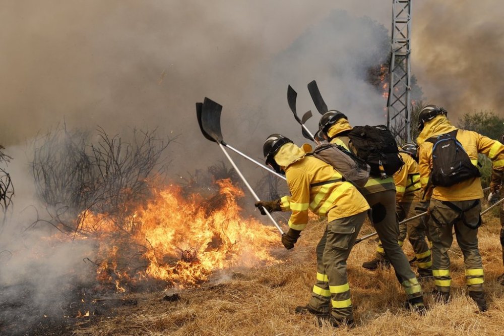 FILE - Firefighters battle a wildfire in Veiga das Meas, northwestern Spain, Saturday, Aug. 16, 2025. (AP Photo/Lalo R. Villar, File)