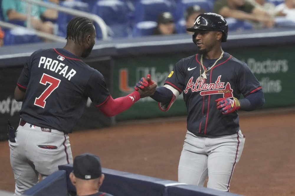 Atlanta Braves' Jurickson Profar (7) congratulates Ozzie Albies after scoring a home run during the fourth inning of a baseball game against the Miami Marlins, Tuesday, Aug. 26, 2025, in Miami. (AP Photo/Marta Lavandier)