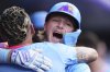 Colorado Rockies' Orlando Arcia, front, hugs Hunter Goodman as he returns to the dugout after hitting a solo home run off Arizona Diamondbacks starting pitcher Brandon Pfaadt in the first inning of a baseball game Friday, Aug. 15, 2025, in Denver. (AP Photo/David Zalubowski)