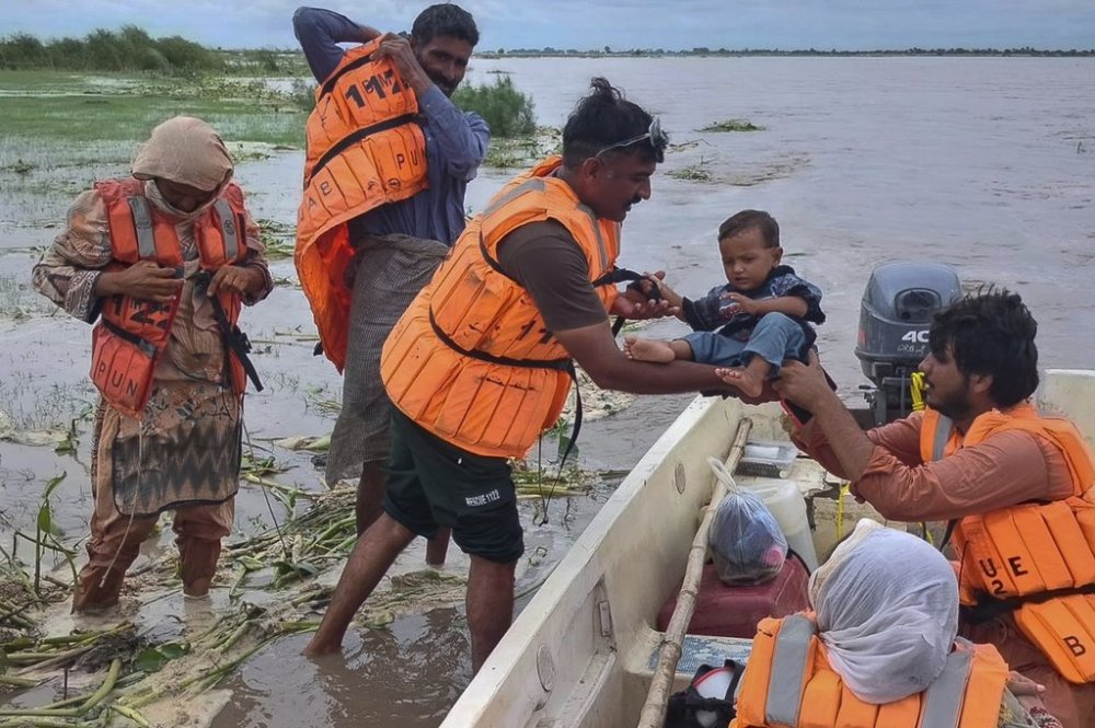 In this photo released by Pakistan's National Disaster Management Authority, rescue workers evacuate villagers from a low-lying area due to rising water level in the Sutlej River following neighbouring India released water from overflowing dams, in Bahawalnagar a district in Pakistan's Punjab province bordering India, Tuesday, Aug. 26, 2025. (Pakistan's National Disaster Management Authority via AP)