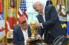 FIFA President Gianni Infantino, right, hands the FIFA World Cup Winners Trophy to President Donald Trump during an announcement in the Oval Office of the White House, Friday, Aug. 22, 2025, in Washington. (AP Photo/Jacquelyn Martin)