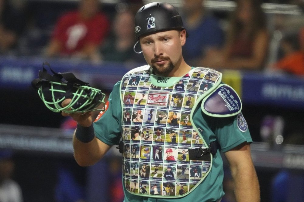 Seattle Mariners catcher Cal Raleigh wears a custom chest protector featuring Little League photos of his teammates for Player's Weekend during the second inning of the Little League Classic baseball game against the New York Mets at Bowman Field in Williamsport, Pa., Sunday, Aug. 17, 2025. (AP Photo/Gene J. Puskar)