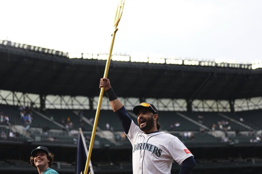 Seattle Mariners' Eugenio Suarez greets fans after the team's win in a baseball game against the San Diego Padres, Wednesday, Aug. 27, 2025, in Seattle. (AP Photo/Lindsey Wasson)