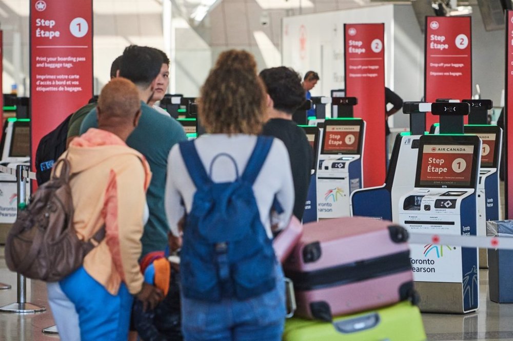 Travellers pass by the Air Canada departure gates as flight attendants picket at Pearson International Airport in Toronto, on Monday, Aug. 18, 2025. THE CANADIAN PRESS/Sammy Kogan