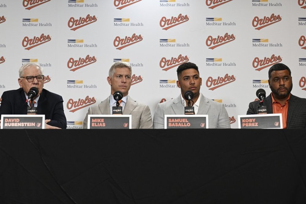 From left to right, Baltimore Orioles owner David Rubenstein, executive vice president and general manager Mike Elias, rookie catcher Samuel Basallo and vice president of international scouting Koby Perez take questions from the media during Basallo's contract extension press conference Saturday, Aug. 23, 2025, in Baltimore. (AP Photo/Terrance Williams)