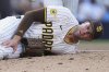 San Diego Padres relief pitcher Jason Adam holds his leg after falling with an injury during the seventh inning of a baseball game against the Baltimore Orioles Monday, Sept. 1, 2025, in San Diego. (AP Photo/Gregory Bull)