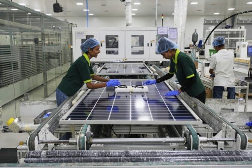 Workers put switches and connectors after they come out of automated framing at a ReNew solar panel manufacturing plant on the outskirts of Jaipur, India, Thursday, Aug. 21, 2025. (AP Photo/Manish Swarup)