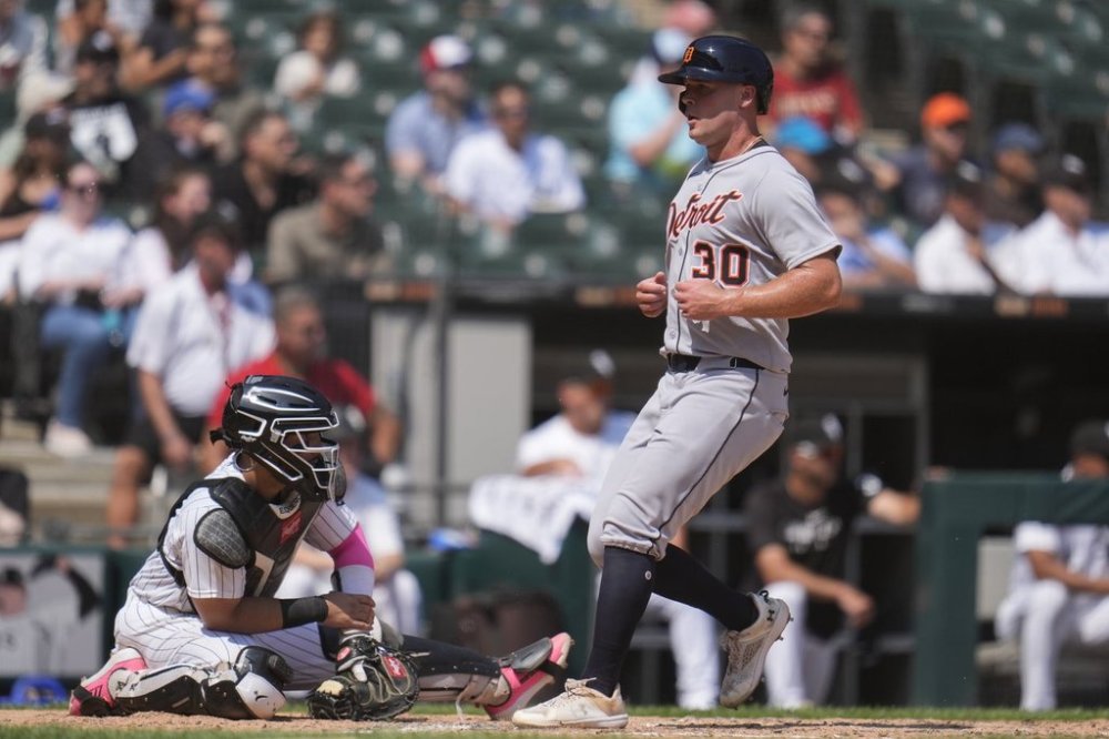 Detroit Tigers' Kerry Carpenter (30) jogs by Chicago White Sox catcher Edgar Quero (7) to score on a sacrifice fly by Wenceel Pérez during the sixth inning of a baseball game Wednesday, Aug. 13, 2025, in Chicago. (AP Photo/Erin Hooley)