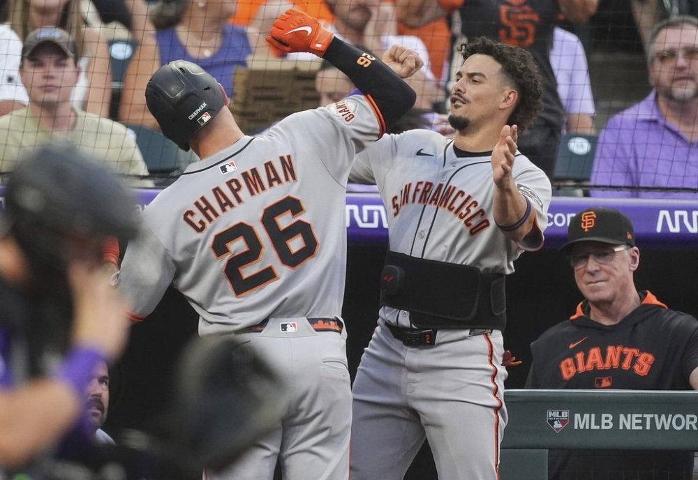 San Francisco Giants' Willy Adames, right, congratulates Matt Chapman (26) as he returns to the dugout after hitting a solo home run off Colorado Rockies starting pitcher Germán Márquez in the second inning of a baseball game Wednesday, Sept. 3, 2025, in Denver. (AP Photo/David Zalubowski)