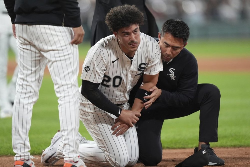 Chicago White Sox first baseman Miguel Vargas is helped by a team trainer after a injury during the fifth inning of a baseball game against the New York Yankees in Chicago, Thursday, Aug. 28, 2025. (AP Photo/Nam Y. Huh)