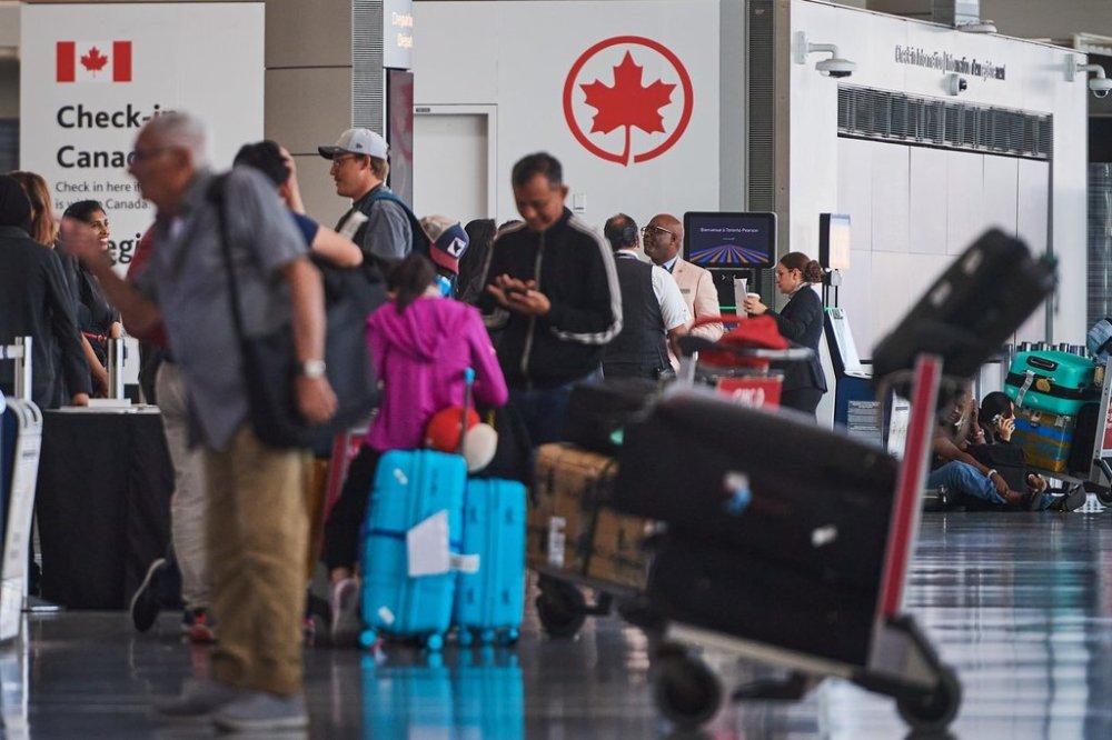 Travellers wait outside the Air Canada departure gates as flight attendants strike at Pearson International Airport in Toronto on Saturday, Aug. 16, 2025. THE CANADIAN PRESS/Sammy Kogan