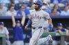 Texas Rangers' Marcus Semien runs home to score on an RBI single hit by Jonah Heim during the second inning of a baseball game against the Kansas City Royals, Monday, Aug. 18, 2025, in Kansas City, Mo. (AP Photo/Charlie Riedel)