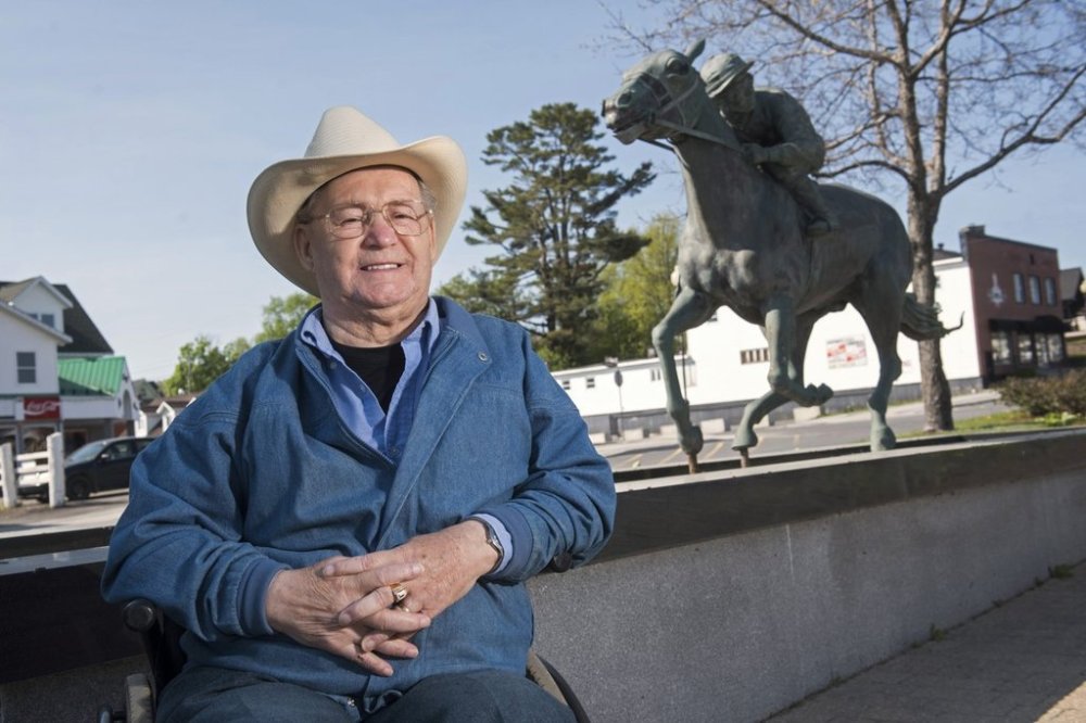 FILE — Ron Turcotte poses next to a statue of him and Secretariat in Grand Falls, New Brunswick, Canada, May 31, 2023. (AP Photo/Stephen MacGillivray, File)