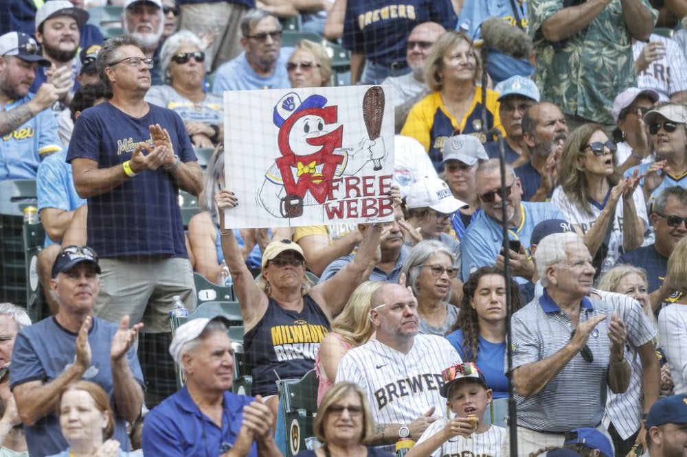 A fan holds up a sign during the fourth inning of a baseball between the Pittsburgh Pirates and Milwaukee Brewers game, Wednesday, Aug.13, 2025, in Milwaukee. (AP Photo/Jeffrey Phelps)