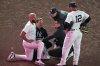 New York Yankees manager Aaron Boone and Trent Grisham (12) watch as trainers check on Amed Rosario during the 10th inning of a baseball game against the Houston Astros Friday, Aug. 8, 2025, in New York. (AP Photo/Frank Franklin II)
