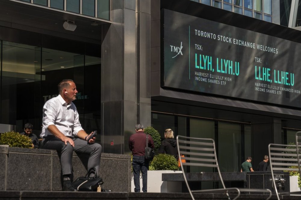 People sit outside the TMX Market Centre in Toronto, Wednesday, Sept. 11, 2024. THE CANADIAN PRESS/Paige Taylor White