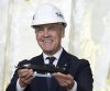 Prime Minister Mark Carney holds up a model submarine he was presented with as he tours Thyssenkrupp Marine Systems (TKMS), a submarine building facility in Kiel, Germany on Tuesday, Aug. 26, 2025. THE CANADIAN PRESS/Christinne Muschi