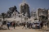 Palestinians run for cover during an Israeli airstrike on a high-rise building in Gaza City, Friday, Sept. 5, 2025, after the Israeli army issued a prior warning. (AP Photo/Yousef Al Zanoun)