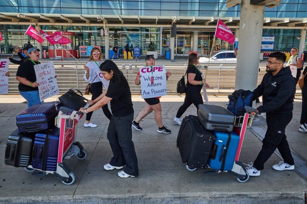 Travellers pass Air Canada flight attendants on strike at Pearson International Airport in Toronto, on Monday, Aug. 18, 2025. THE CANADIAN PRESS/Sammy Kogan