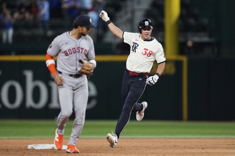Texas Rangers' Dustin Harris, right, celebrates his game winning double as Houston Astros shortstop Jeremy Pena looks on in the 12th inning of a baseball game Friday, Sept. 5, 2025, in Arlington, Texas. (AP Photo/Tony Gutierrez)
