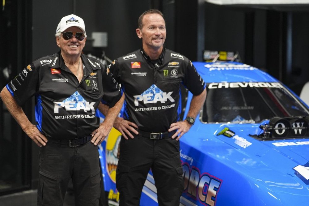 Drag racing car owner John Force, left, and funny car driver Jack Beckman pose next to the team's newest car, Thursday, Aug. 28, 2025, in Zionsville, Ind. (AP Photo/Michael Conroy)