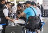 An Air Canada employee hands out snacks to travellers waiting for a flight at Montreal-Pierre Elliott Trudeau International Airport in Dorval, Que., on Tuesday, Aug. 19, 2025. THE CANADIAN PRESS/Christinne Muschi