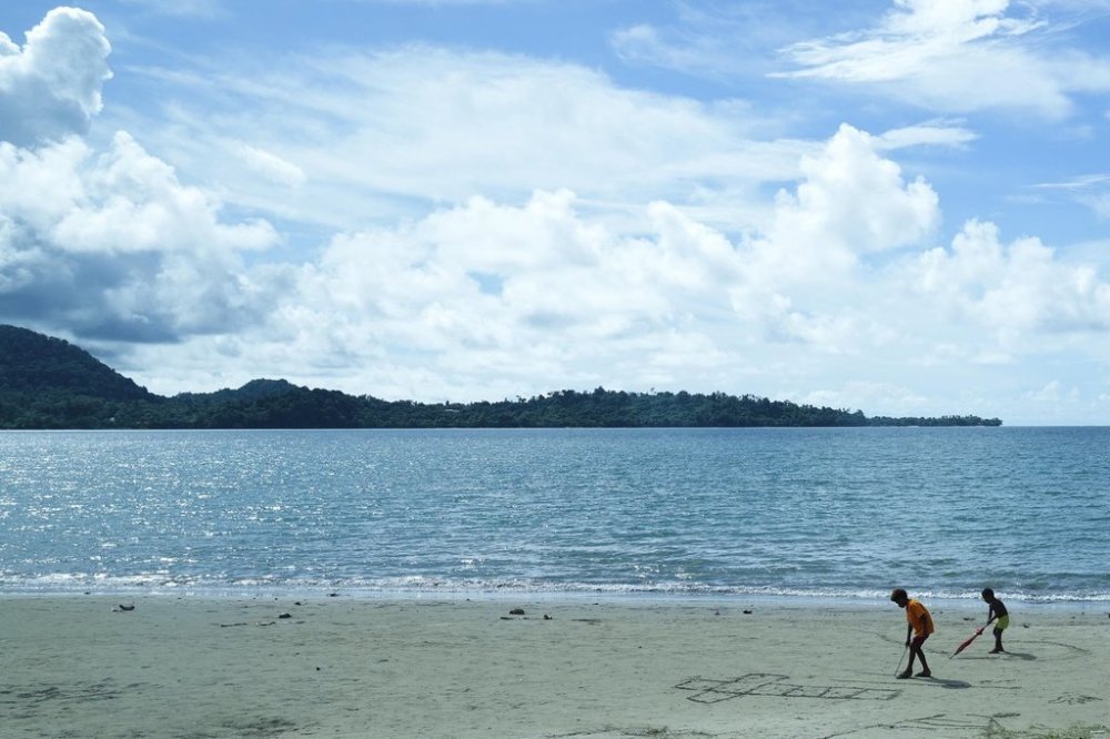 FILE - Children draw crosses on a sandy beach in Vanimo, Papua New Guinea, Sunday, Sept. 8, 2024. (AP Photo/Gregorio Borgia, File)