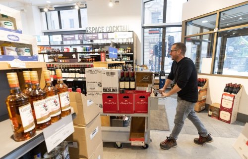 An employee removes American wines from an SAQ liquor store in Montreal on Tuesday, March 4, 2025. THE CANADIAN PRESS/Christinne Muschi
