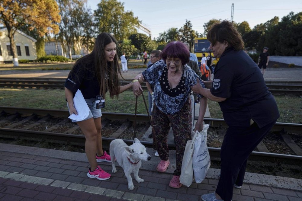 Tetiana Zaichikova, center, walks on a platform during evacuation at the train station in Lozova, Ukraine, Wednesday, Sept. 3, 2025. (AP Photo/Evgeniy Maloletka)