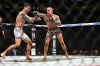 Dustin Poirier, right, hits Max Holloway in a lightweight title fight at UFC 318 in New Orleans, La., Saturday, July 19, 2025. (AP Photo/Ella Hall)