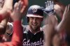 Washington Nationals' Nathaniel Lowe celebrates in the dugout after hitting a grand slam during the first inning of a baseball game against the Kansas City Royals, Wednesday, Aug. 13, 2025, in Kansas City, Mo. (AP Photo/Charlie Riedel)
