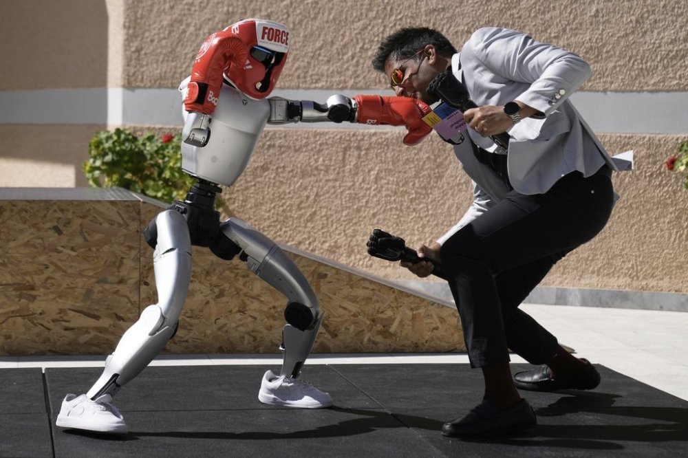 The Unitree G1 robot plays boxing with Aadeel Akhtar CEO and Founder of Psyonic at the first International Humanoid Olympiad at the Olympic Academy, in ancient Olympia, Greece, Monday, Sept. 1, 2025. (AP Photo/Thanassis Stavrakis)