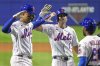 New York Mets third base Mark Vientos, left, is greeted by Jeff McNeil (1), and Cedric Mullins (28) as he returns to the dugout after hitting a three-run home run off Seattle Mariners pitcher George Kirby during the fifth inning of the Little League Classic baseball game at Bowman Field in Williamsport, Pa., Sunday, Aug. 17, 2025. (AP Photo/Gene J. Puskar)