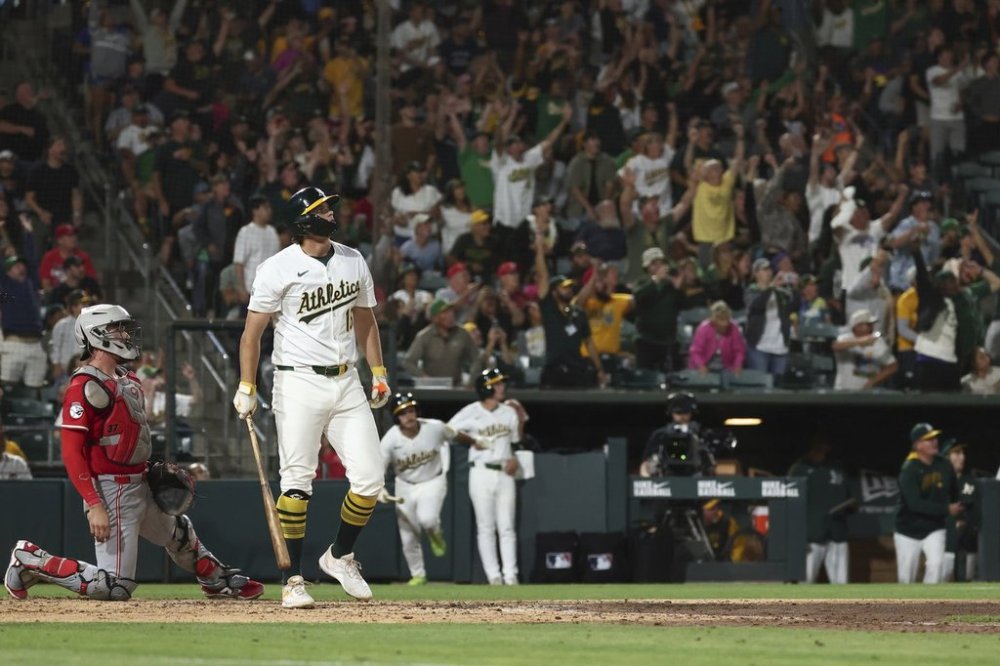Athletics' Nick Kurtz, right, watches the ball after hitting a grand slam during the eighth inning of a baseball game against the Cincinnati Reds Saturday, Sept. 13, 2025, in West Sacramento, Calif. (AP Photo/Sara Nevis)