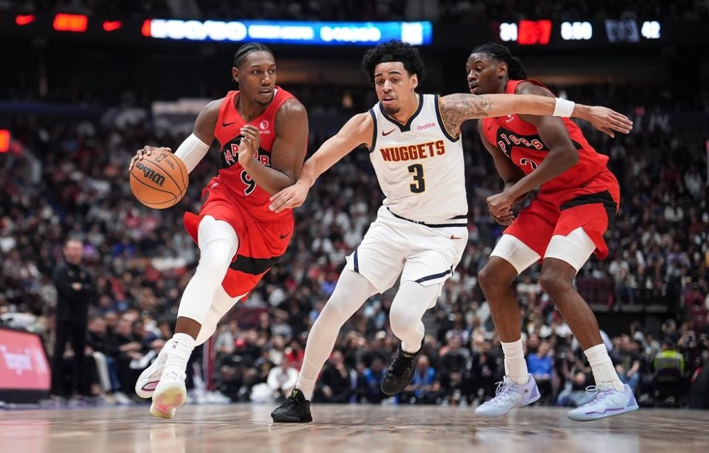 Toronto Raptors' RJ Barrett, left, drives past Denver Nuggets' Julian Strawther, centre, in front of Toronto's Jonathan Mogbo, back right, during the first half of a pre-season NBA basketball game, in Vancouver, B.C., Monday, Oct. 6, 2025. THE CANADIAN PRESS/Darryl Dyck