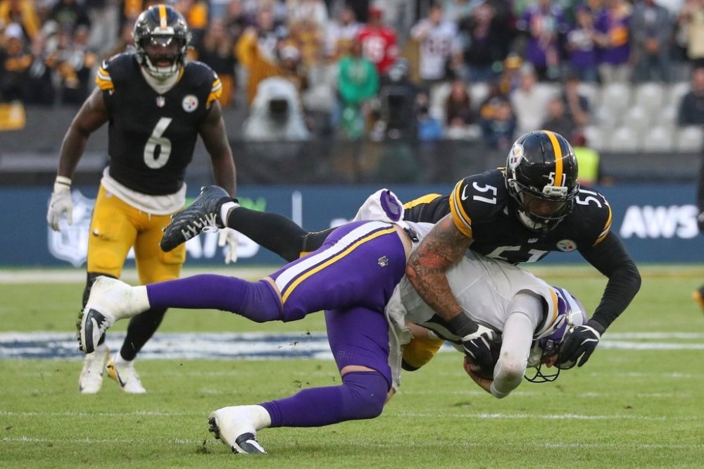 Pittsburgh Steelers linebacker Nick Herbig (51) and Minnesota Vikings quarterback Carson Wentz (11) challenge for the ball during the NFL football game between Minnesota Vikings and Pittsburgh Steelers at Croke Park stadium in Dublin, Sunday, Sept. 28, 2025.(AP Photo/Peter Morrison)