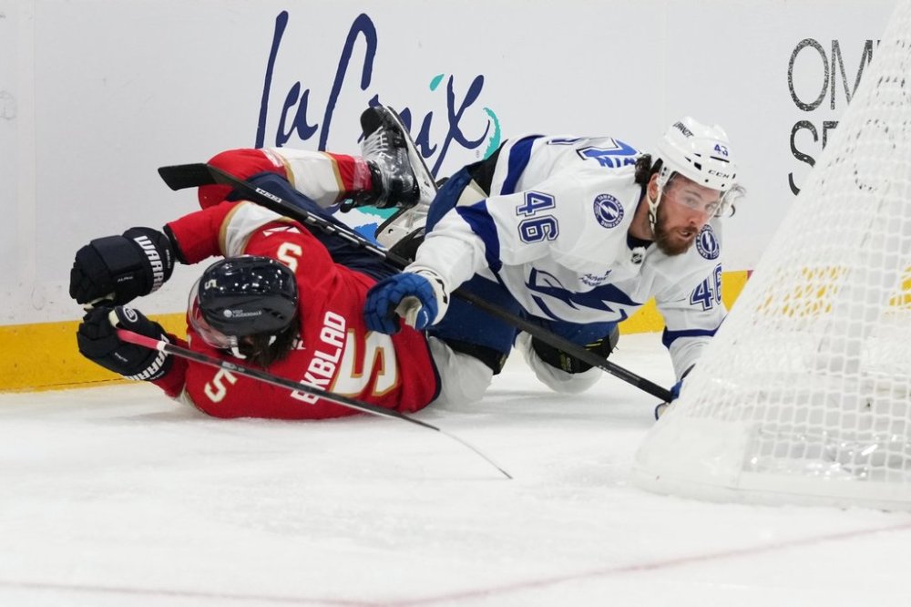 Florida Panthers defenseman Aaron Ekblad (5) and Tampa Bay Lightning right wing Scott Sabourin (46) fall to the ice during the first period of an NHL hockey preseason game, Saturday, Oct. 4, 2025, in Sunrise, Fla. (AP Photo/Lynne Sladky)