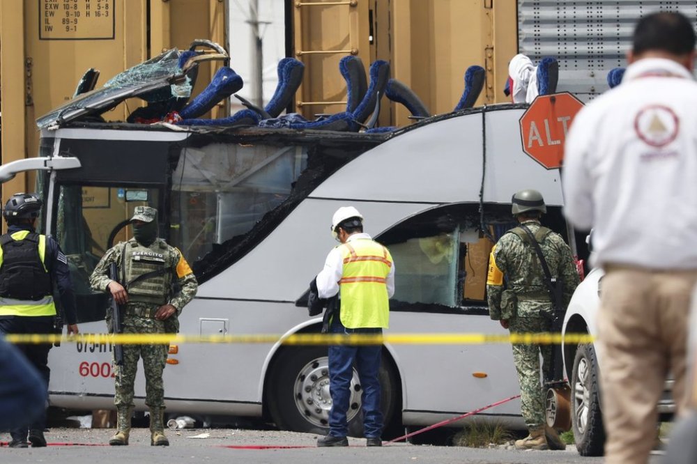 Soldiers and rescue personal work the scene of a deadly accident where a freight train slammed into a double-deck bus in Atlacomulco, Mexico, Monday, Sept. 8, 2025. (AP Photo/Ramses Mercado Valdes)